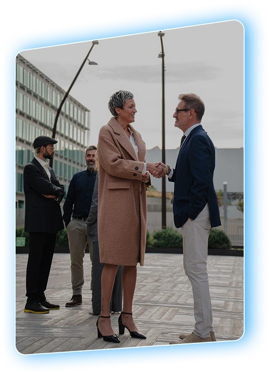 Two professionals shaking hands outside an office building